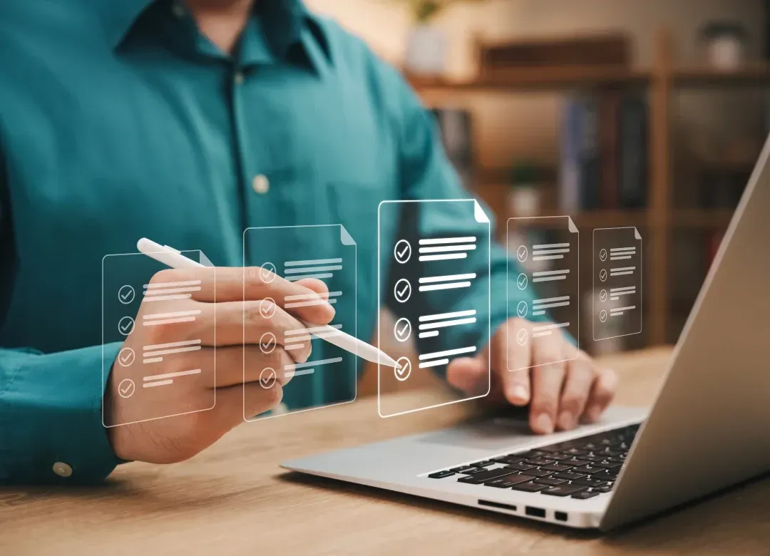 Person reviewing a hiring checklist on a laptop with digital candidate evaluation forms on screen