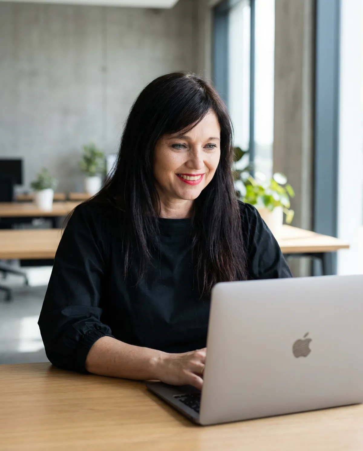 alt="Monica Visca, founder of Brand With Attitude, standing at the bar "