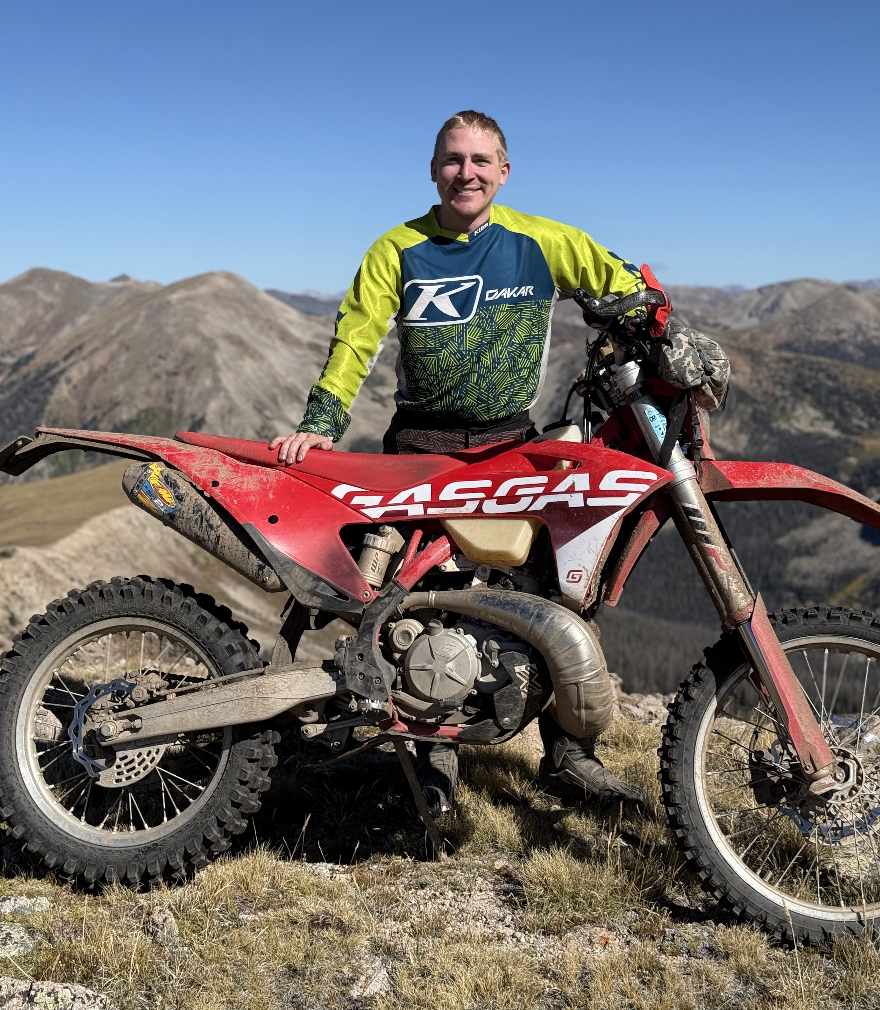Austin Wendel with his dirt bike on a Colorado mountain ridge