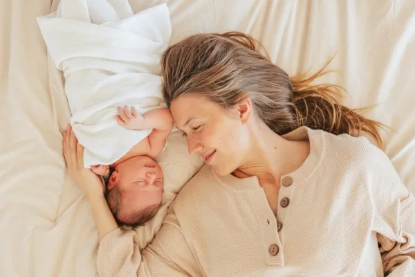 mother and her newborn baby resting on bed