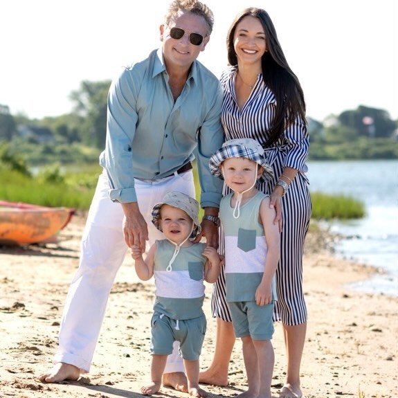 Portrait of a smiling woman with a young boy and girl outdoors.