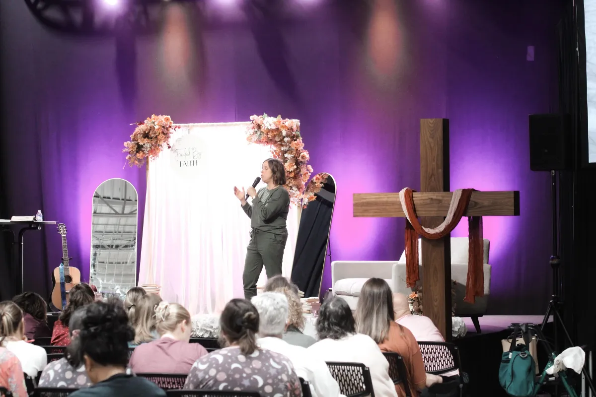 two women sitting at a table looking at a computer screen