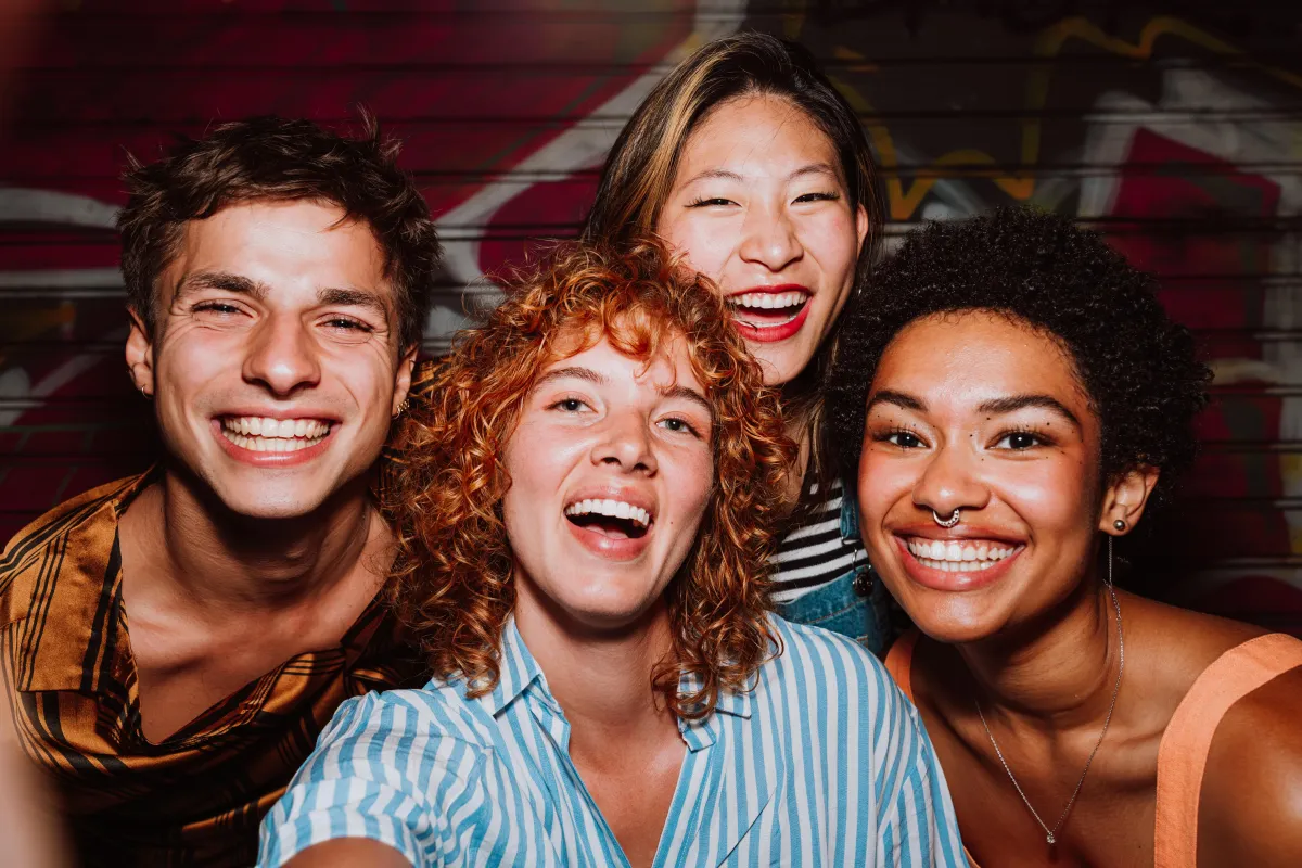 Group of friends celebrating at a wedding in College Station, Texas. Joyful guests laughing and taking a selfie at a wedding reception, showcasing fun and vibrant wedding entertainment.