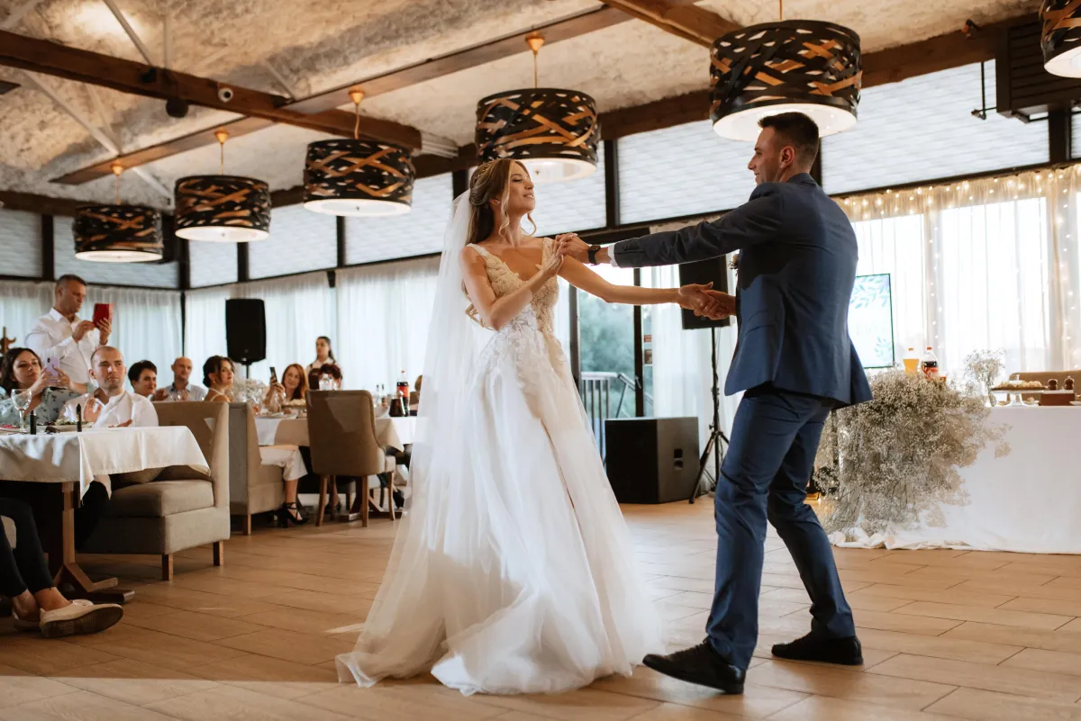 Bride and groom sharing their first dance at an elegant wedding reception, with professional DJ services by Dynamic Celebrations.