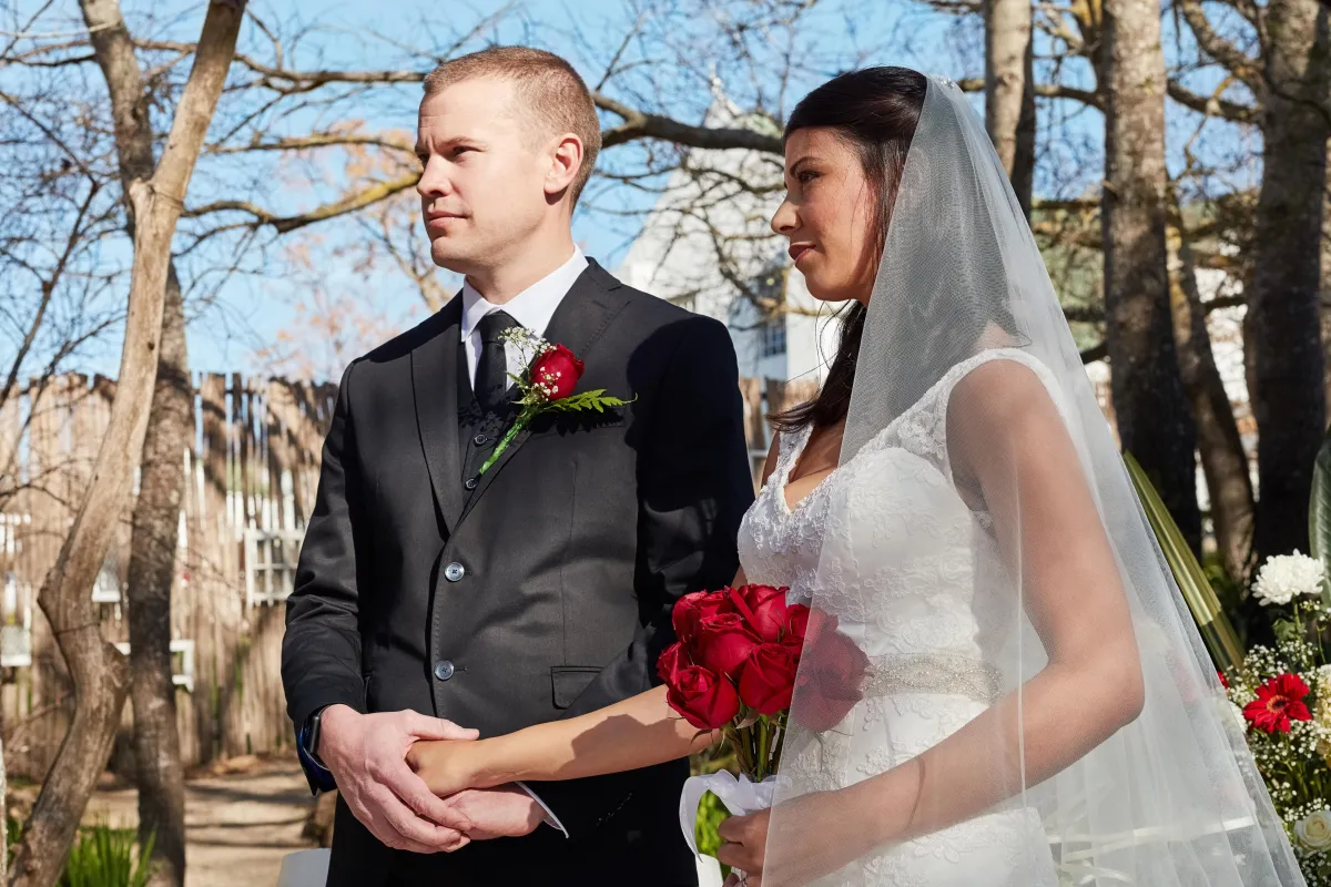 Bride and groom holding hands as they exchange vows in a picturesque outdoor ceremony officiated in Texas.