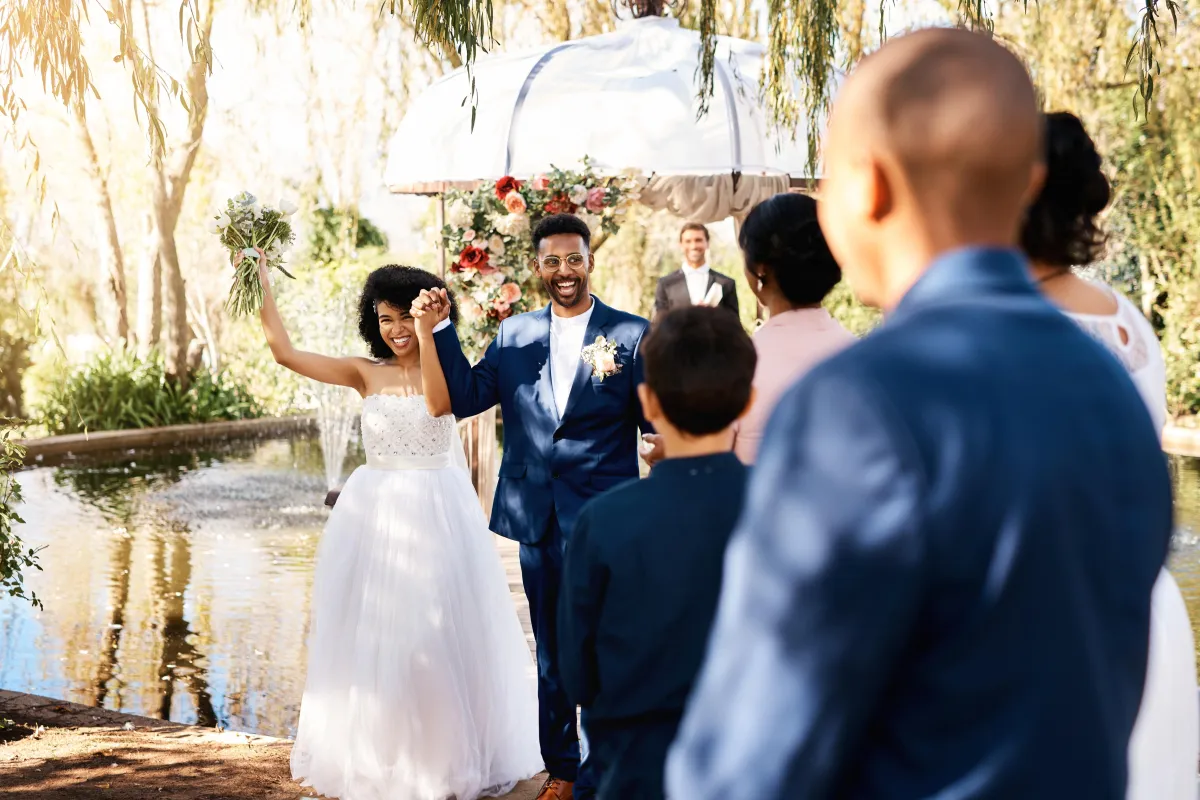 Newlywed couple celebrating their wedding ceremony in San Antonio, Texas, surrounded by family and friends at a beautiful outdoor venue.