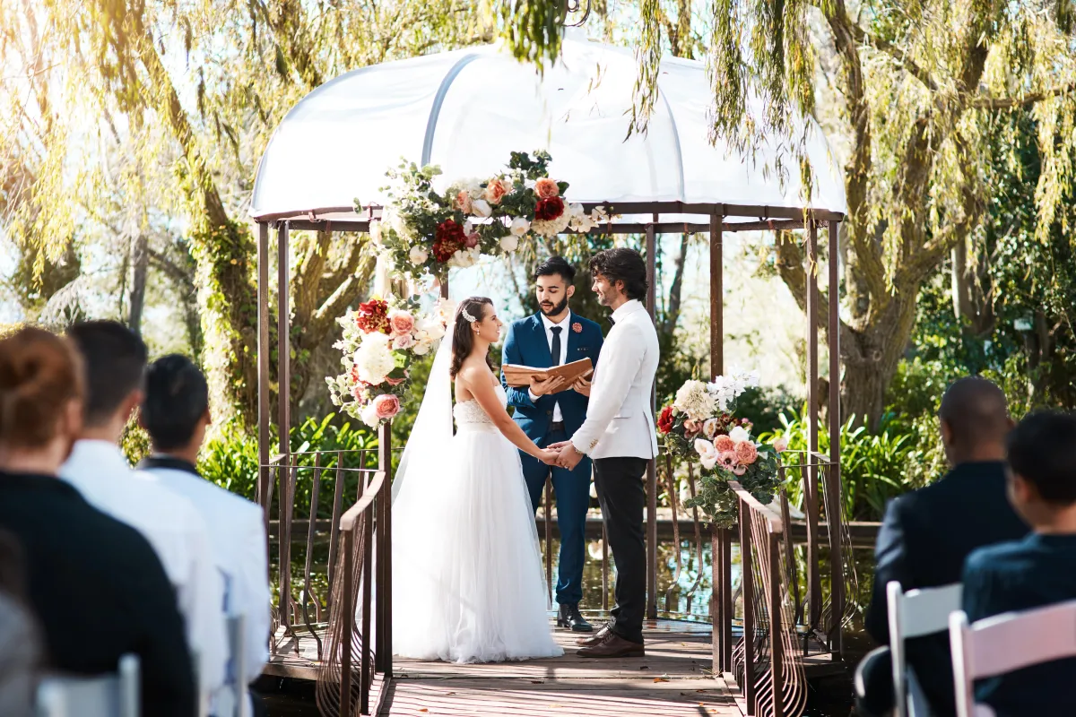 Romantic outdoor wedding ceremony under a floral arch, officiated by an experienced Texas wedding officiant.