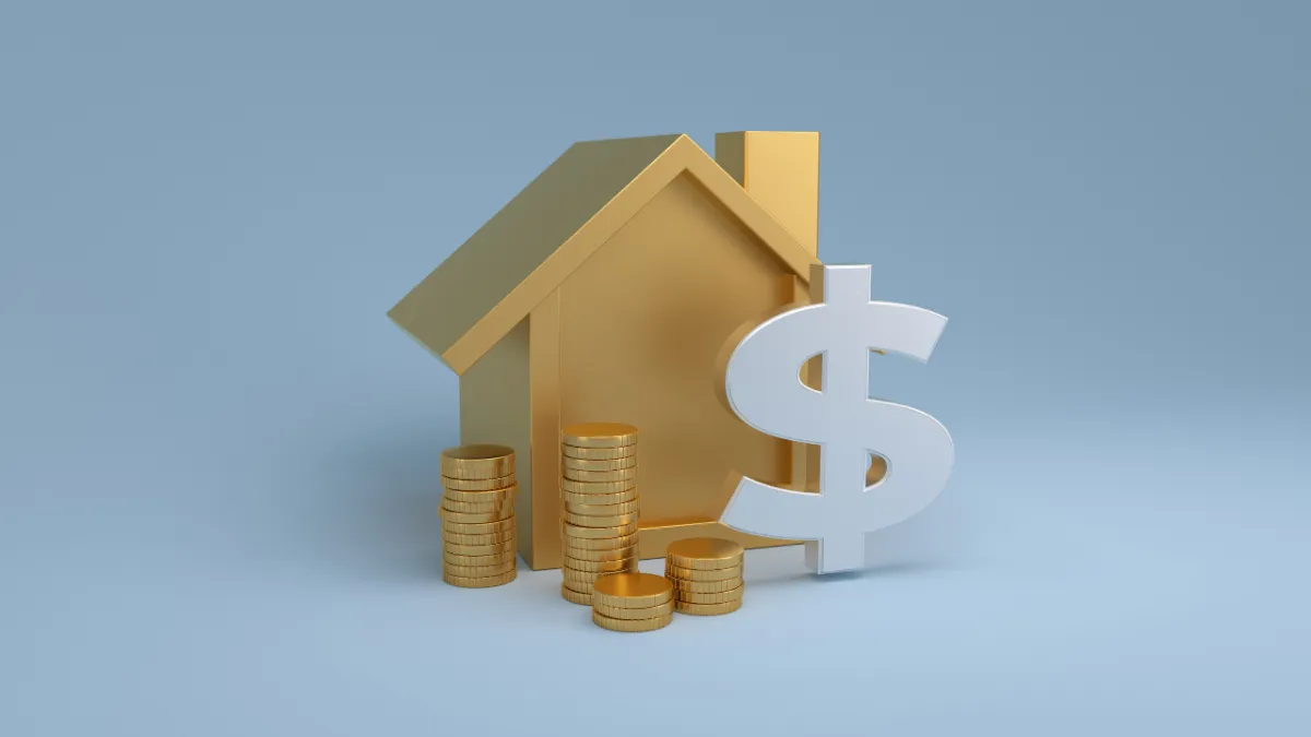 Real estate agent reviewing financial documents and clipboard next to a model house on a desk