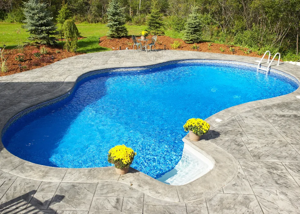 Custom swimming pool with decorative concrete decking designed for luxury outdoor living by Miami Builders.