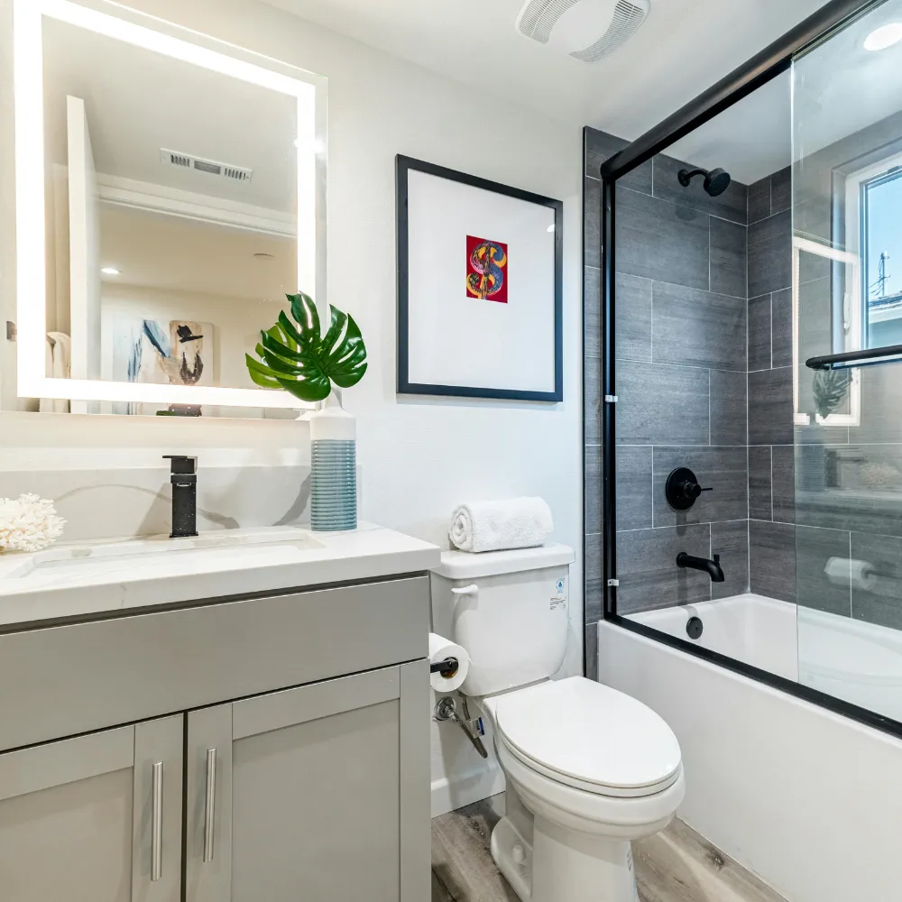 Modern bathroom renovation with a glass shower enclosure, custom vanity, and elegant tile by Miami Builders.