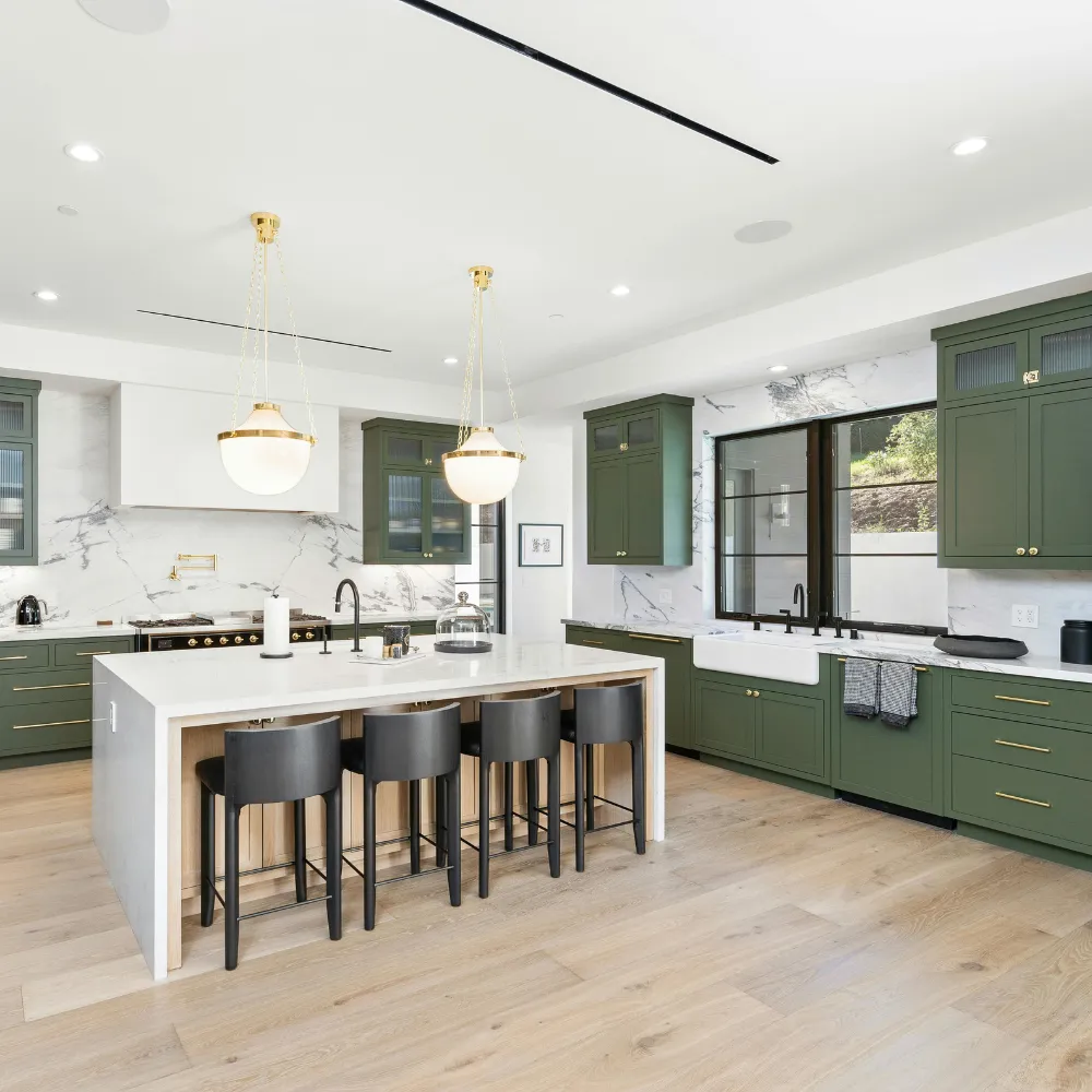 Custom kitchen remodeling featuring green cabinetry, quartz countertops, and a spacious center island by Miami Builders.