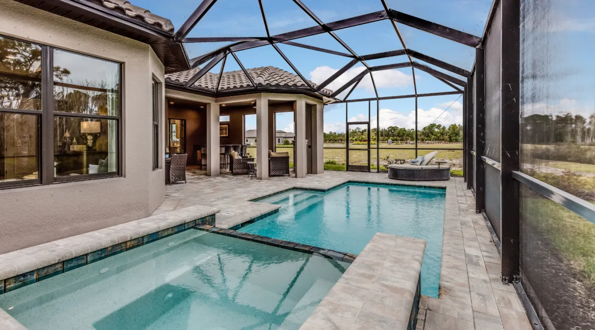 Luxury custom swimming pool with screened enclosure, elegant patio, and outdoor living space designed by Miami Builders.