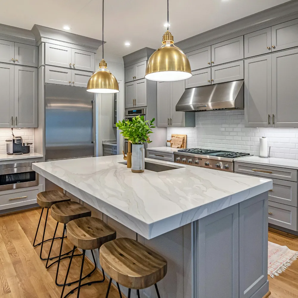 Luxury kitchen renovation with custom gray cabinetry, quartz island, and designer pendant lighting by Miami Builders.