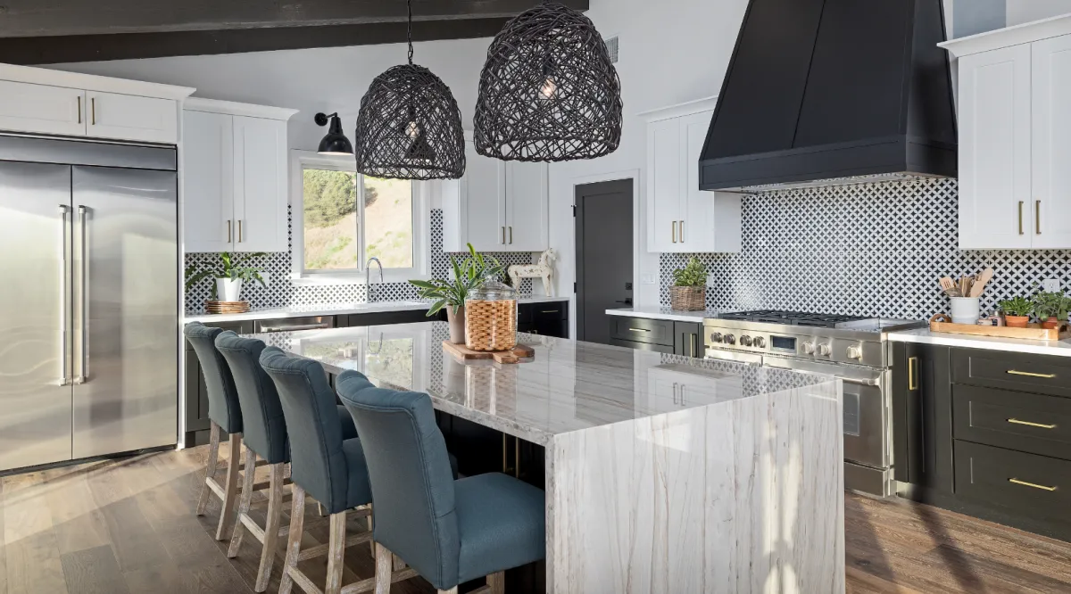 Luxury kitchen remodeling featuring a waterfall quartz island, custom cabinetry, designer lighting, and premium finishes by Miami Builders.