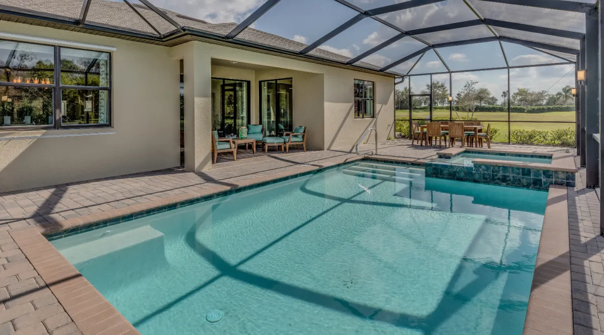 Luxury custom swimming pool with screened enclosure, spacious patio, and elegant outdoor living area designed by Miami Builders.