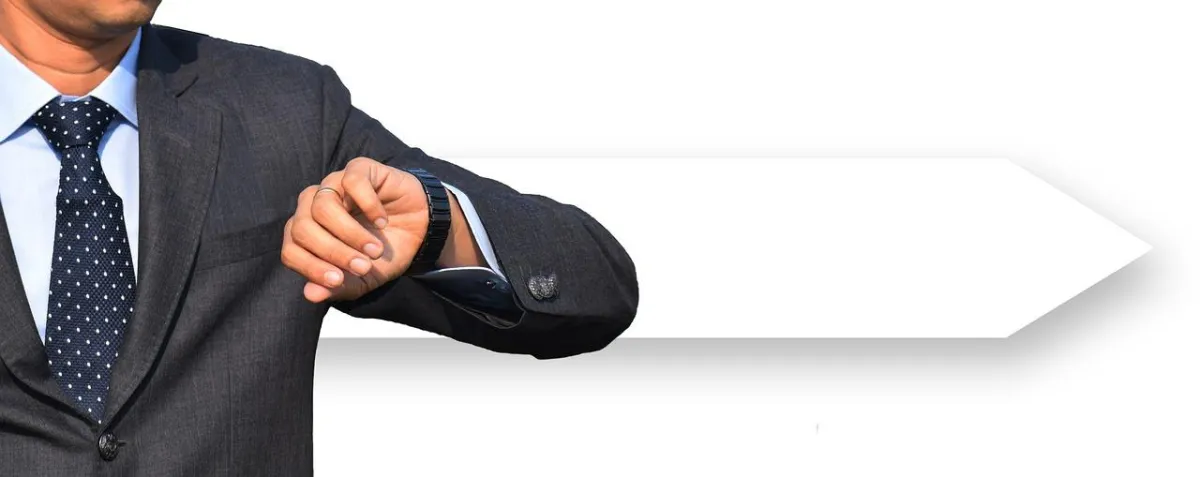 A person in a gray suit and blue polka-dotted tie checks their wristwatch, with a white arrow graphic extending behind their arm.