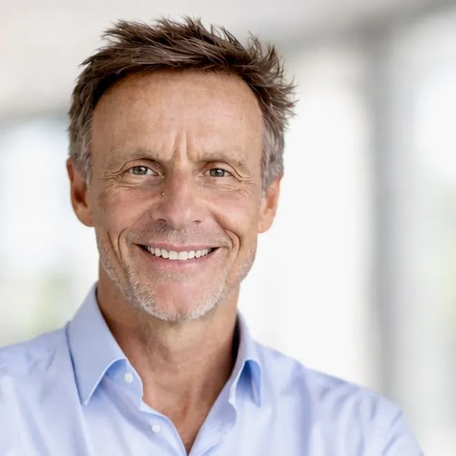 Katharina Isenegger berät dich in einem hellen, modernen Büro, umgeben von Pflanzen und natürlichem Licht. Beide Frauen lächeln und vermitteln Empathie und Professionalität in einer klaren, Apple‑inspirierten Umgebung.