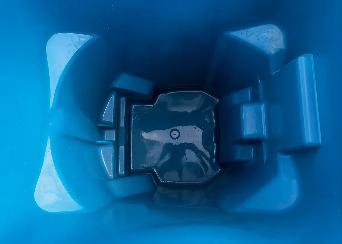 Interior of a freshly cleaned blue trash bin showing a spotless, shiny surface.