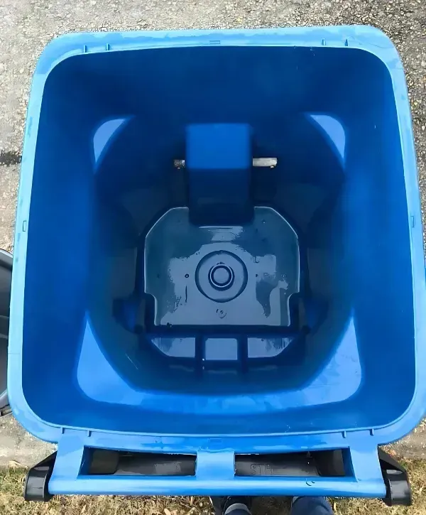Top view of a freshly cleaned blue trash bin on pavement
