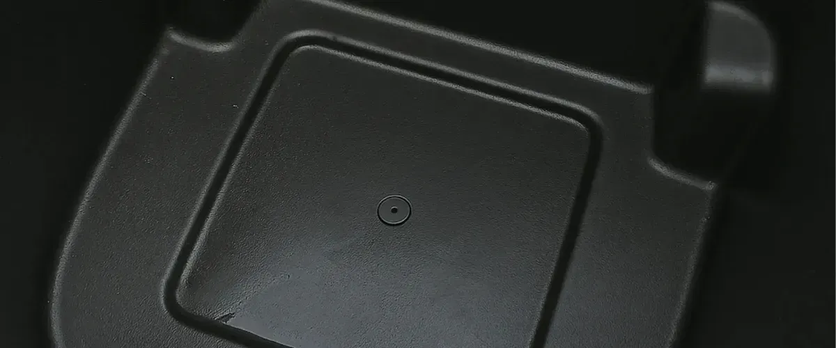 Close-up view of a clean black trash bin bottom interior