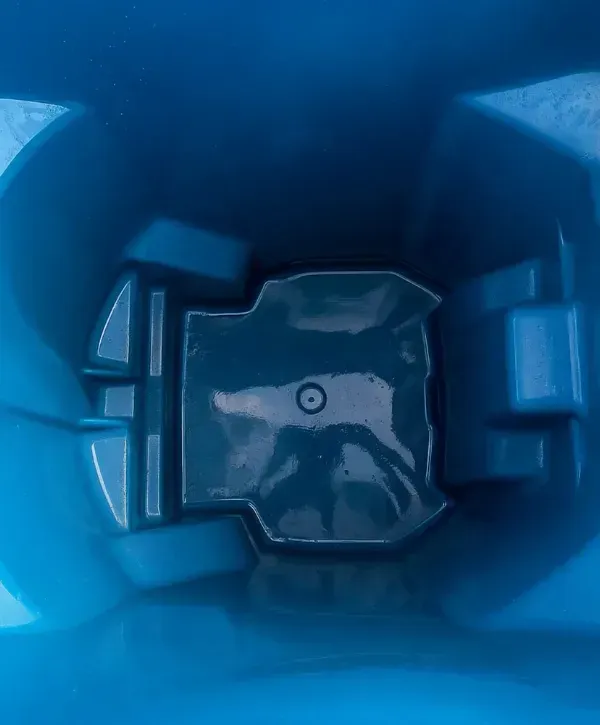 Interior bottom of a blue garbage bin, freshly cleaned and shiny