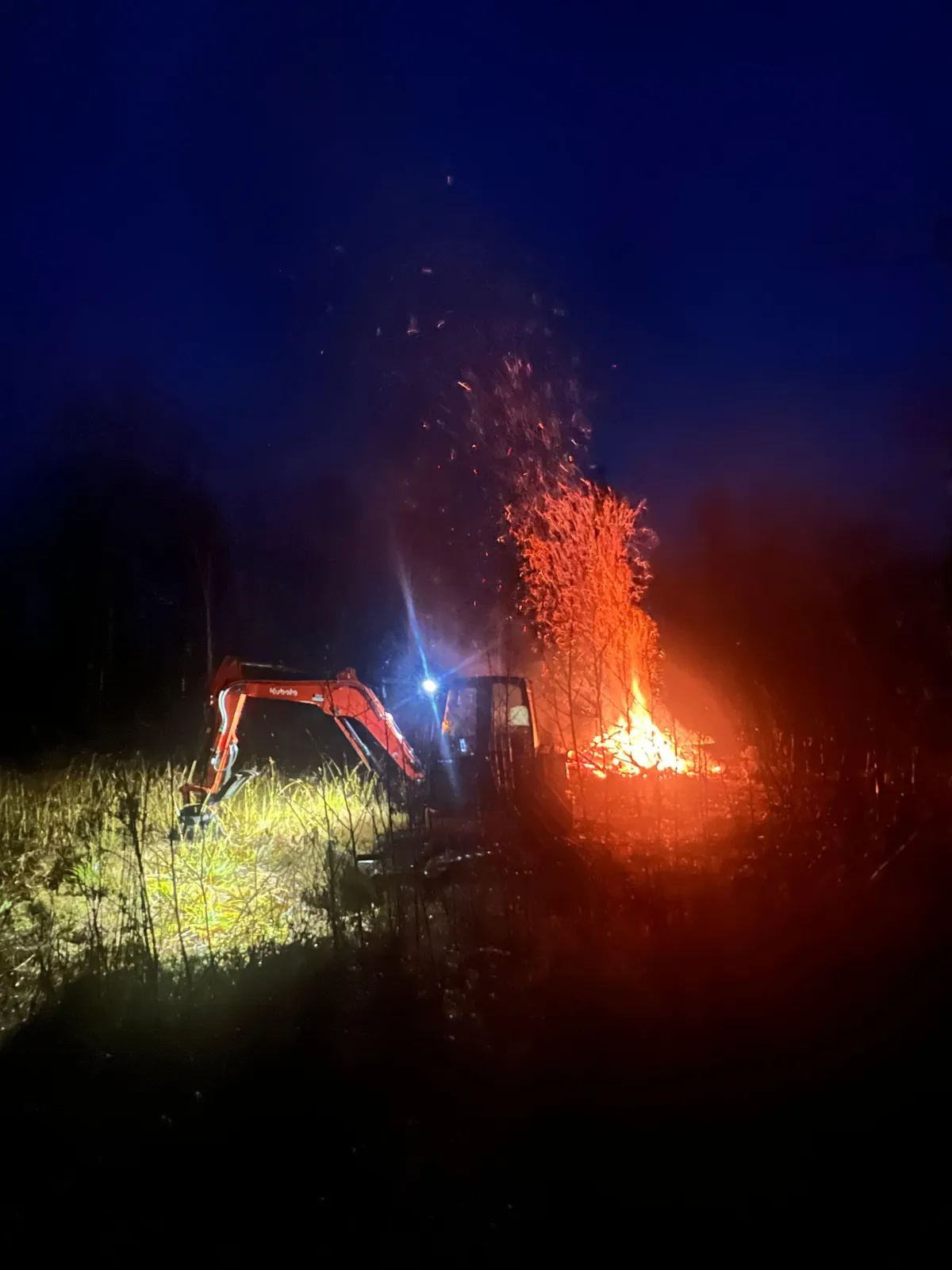 Professional wildfire mitigation and land clearing service with excavator performing brush removal and fire prevention work.