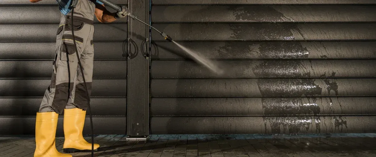 Commercial pressure washing of metal garage door and exterior wall
