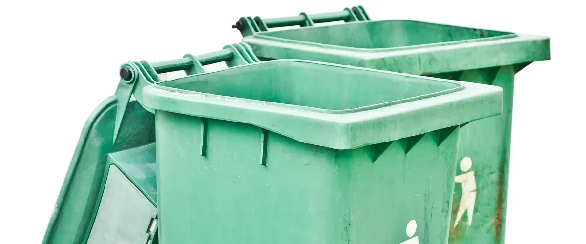 Empty green trash bins with lids open