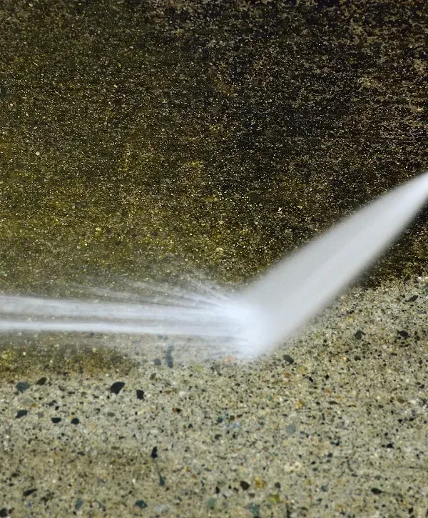 Power washing removing grime from textured concrete surface