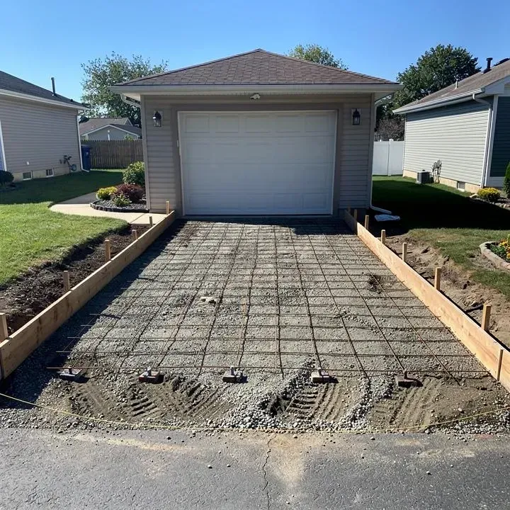 Prepared residential driveway site with gravel base and rebar reinforcement ready for concrete pour in North Tonawanda, New York