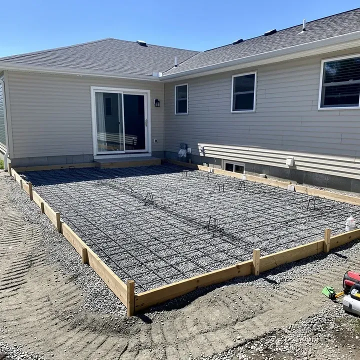 Prepared residential patio site with gravel base and rebar reinforcement ready for concrete pour in North Tonawanda, New York