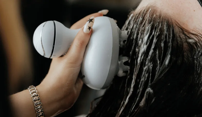Specialist using a scalp massage tool during the Hana scalp ritual
