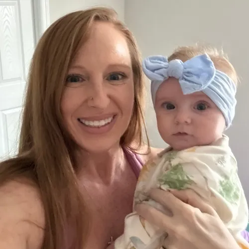 Crystal working out at home with baby nearby on a play mat