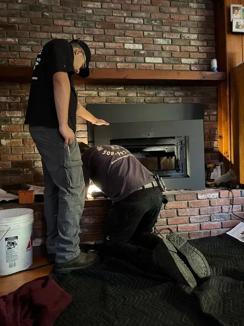 Inspector examining the inside of a chimney flue with a flashlight and camera