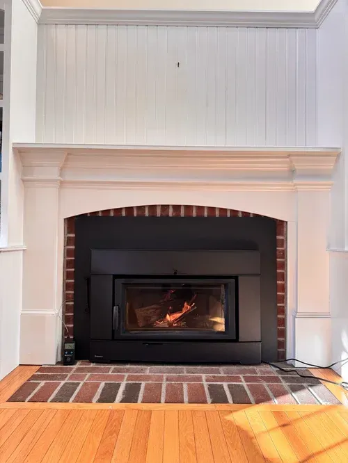 Mason restoring an old brick fireplace with mortar and tools