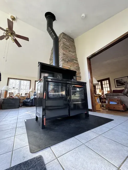 Technician installing a pellet stove and connecting venting to the chimney