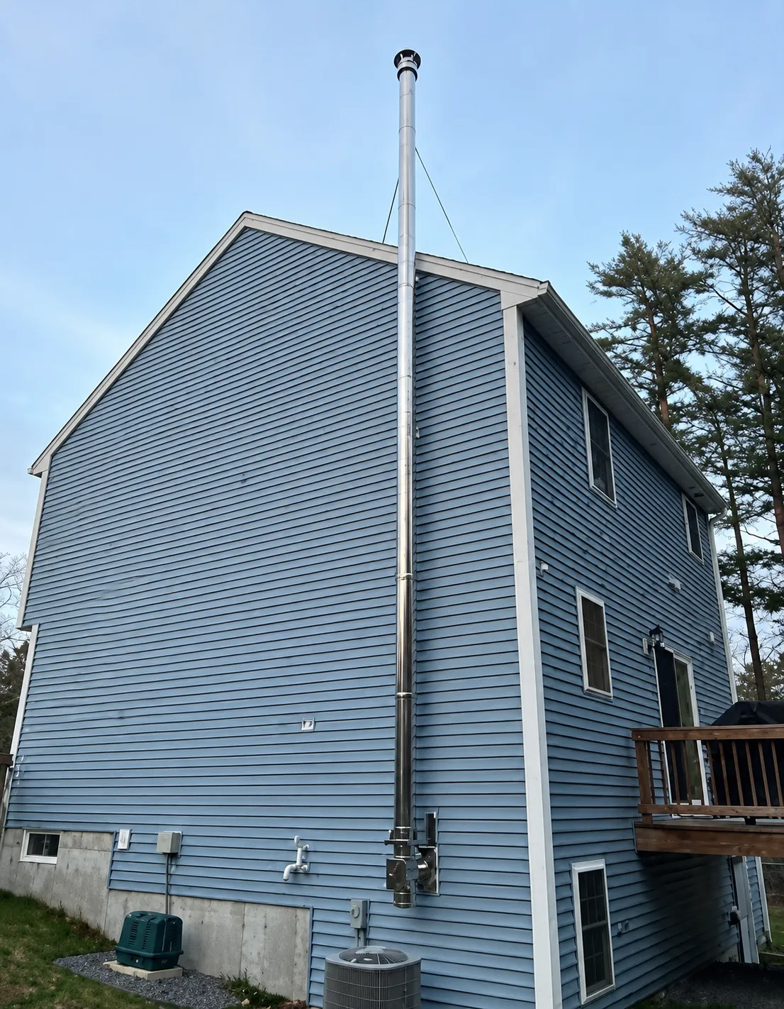 Technicians installing prefabricated metal chimney sections on a roof