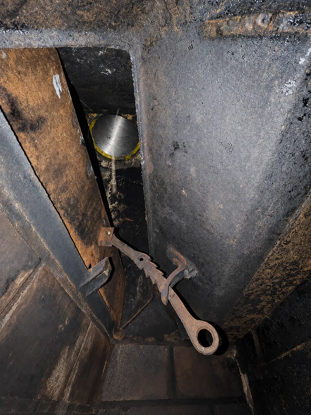 Close-up of a technician repairing a chimney damper mechanism