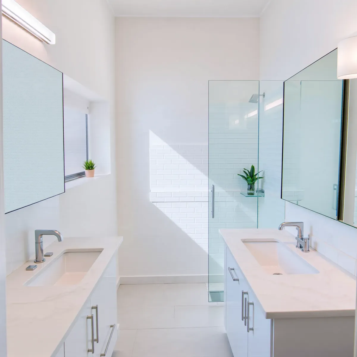 Small modern bathroom in Torrance with neutral tiles, compact vanity, glass shower, framed mirror, and soft LED lighting.