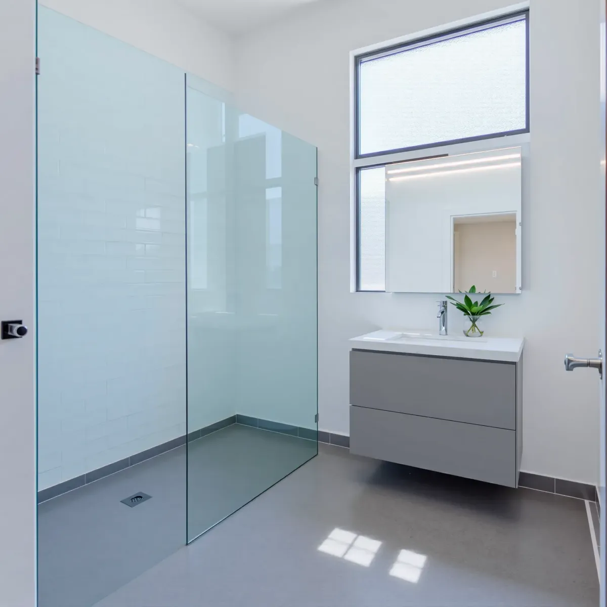 Bright renovated Hawthorne, CA bathroom with white marble countertops, glass shower, chrome fixtures, and modern decor.