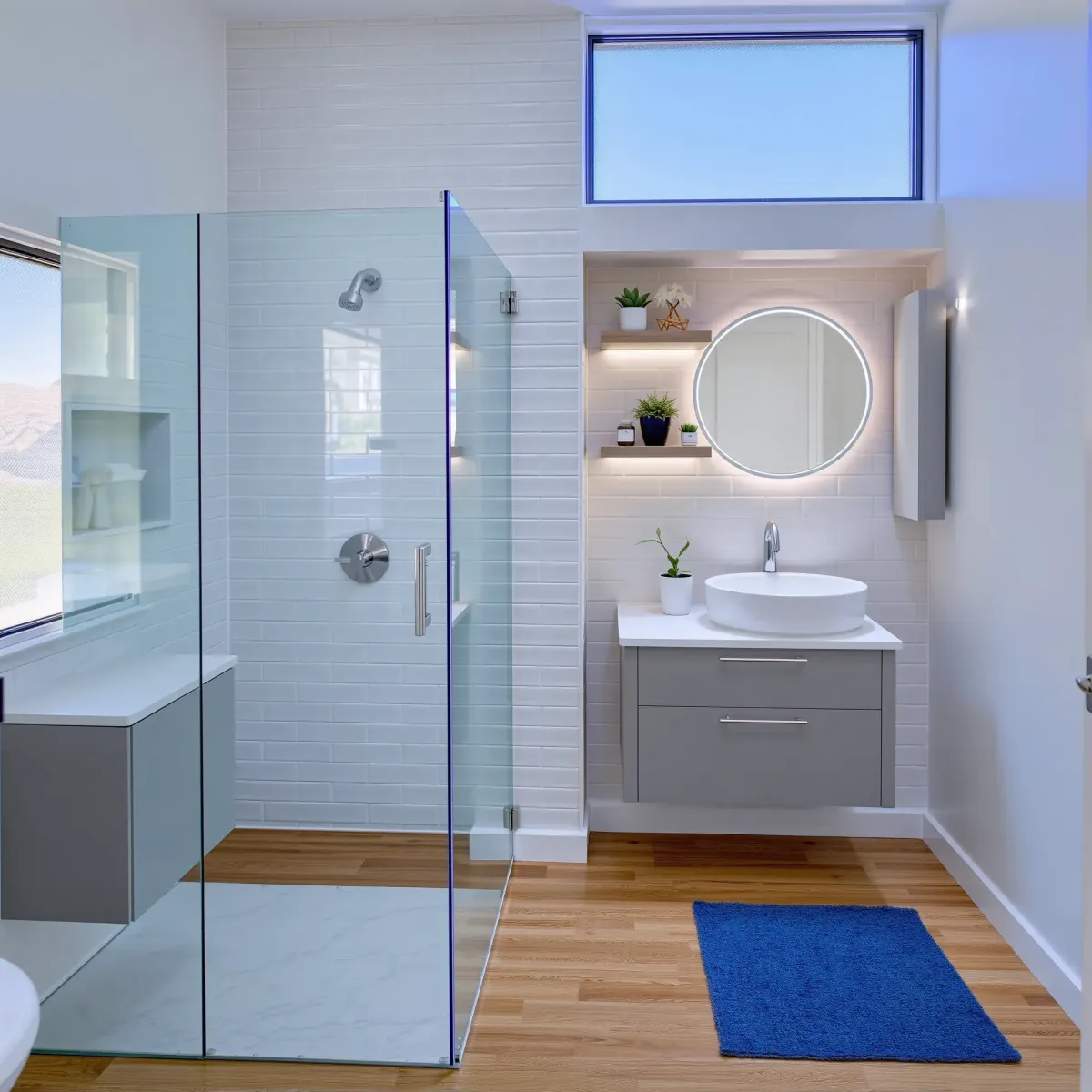 Small modern bathroom in Culver City with gray tiles, marble counter, glass shower, and sleek floating vanity.