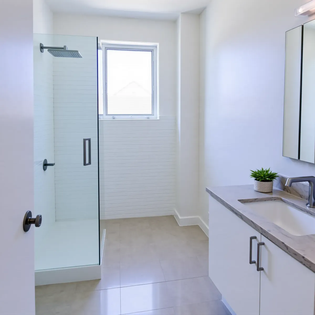 Renovated small bathroom in West Adams, CA with white subway tile shower, floating vanity, natural light, and neutral tones.