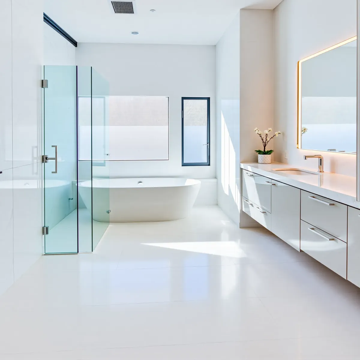 Renovated Westchester, CA bathroom with marble floors, freestanding tub, walk-in shower, double vanity, and modern decor.