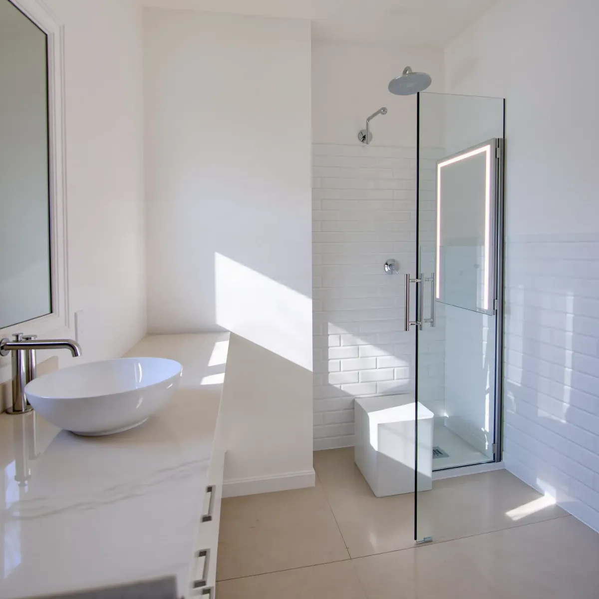 Remodeled small bathroom in Mid Wilshire, CA with modern fixtures, marble countertop, subway tiles, and natural sunlight.