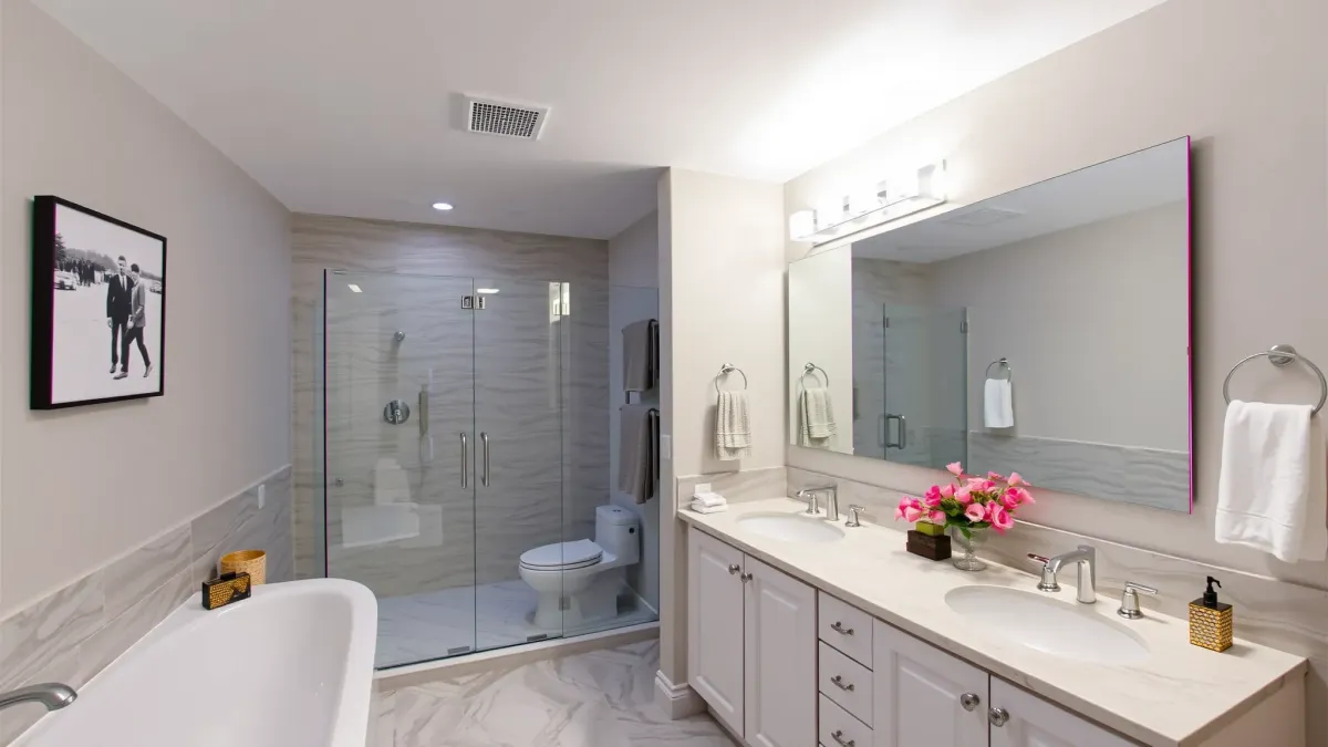 Modern remodeled bathroom in Palms, CA with walk-in shower, freestanding tub, marble vanity, and natural light.