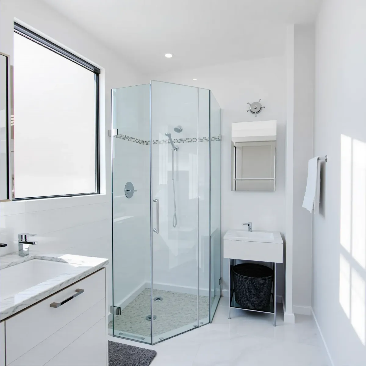 Modern small bathroom in Lennox, CA with white tiles, chrome fixtures, granite vanity, glass shower, and natural light.