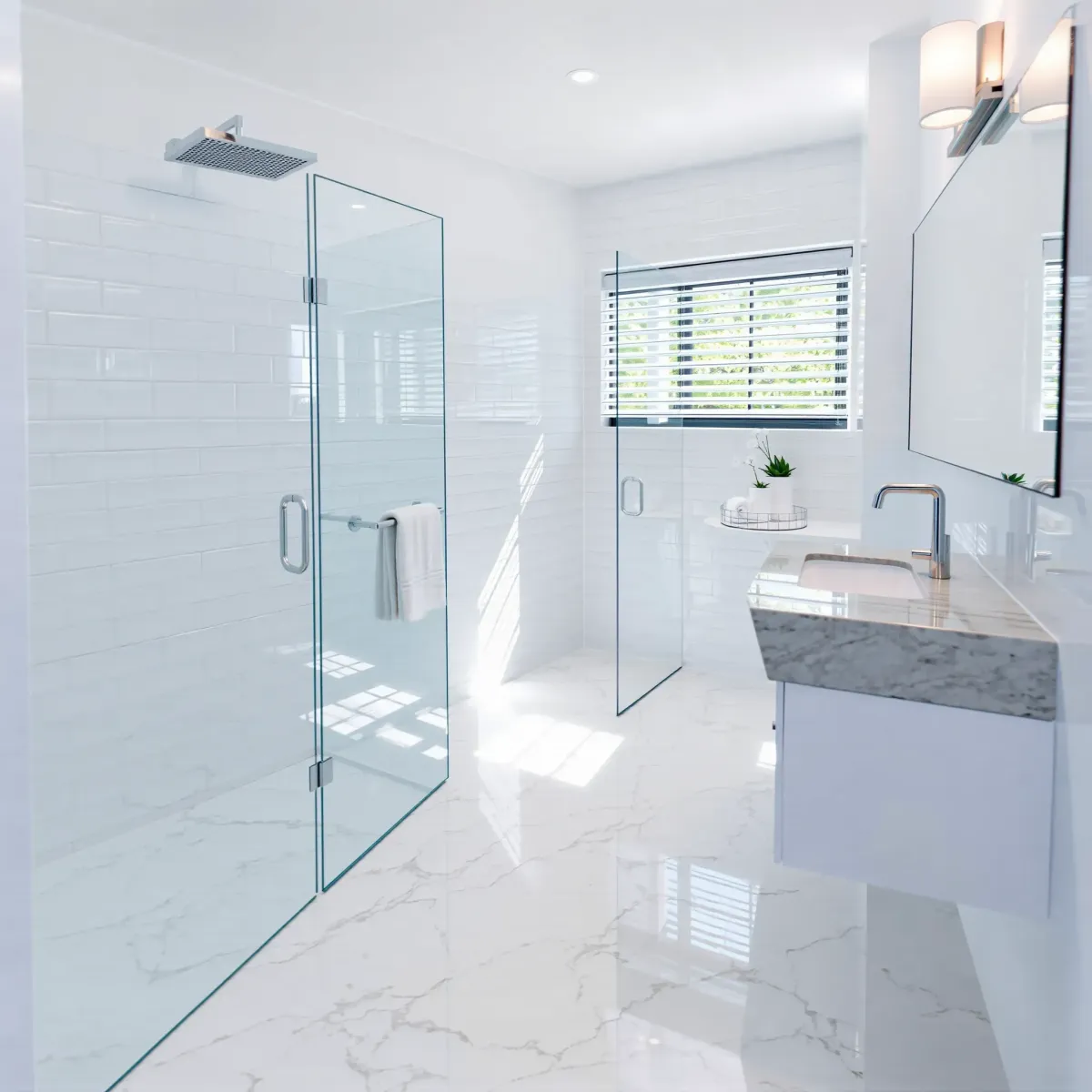 Bright Inglewood bathroom with marble floor, white subway tiles, sleek fixtures, glass shower, floating vanity, and natural light.