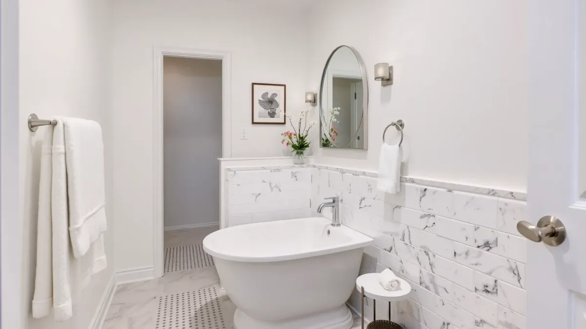Renovated Manhattan Beach bathroom with white tiles, gray subway accents, modern vanity, glass shower, and coastal decor.