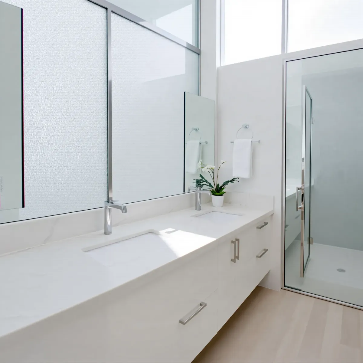 Remodeled West Adams bathroom featuring marble countertops, glass shower, modern fixtures, natural light, and neutral tones.