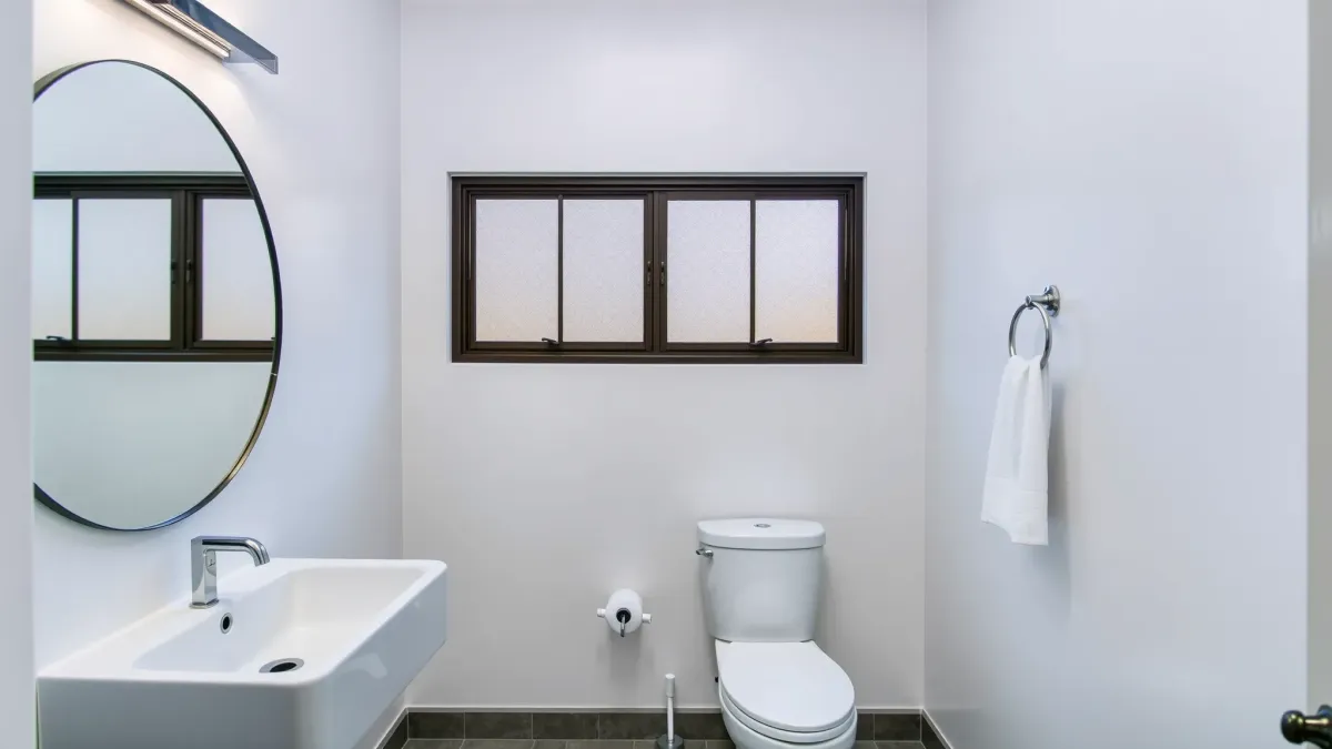 Remodeled small Carson, CA bathroom with sleek fixtures, marble tiles, minimalist design, natural light, and modern storage.